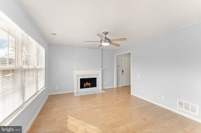 a view of an empty room with a fireplace and a window