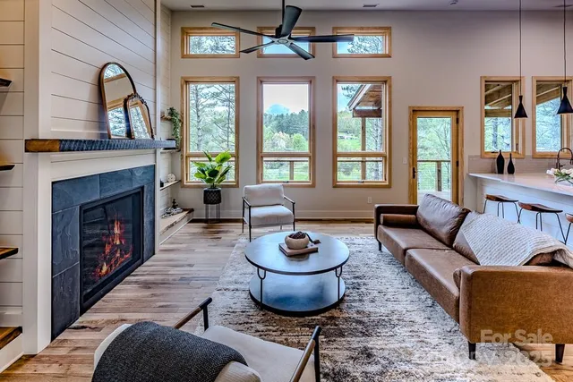 a living room with furniture a fireplace and a large window