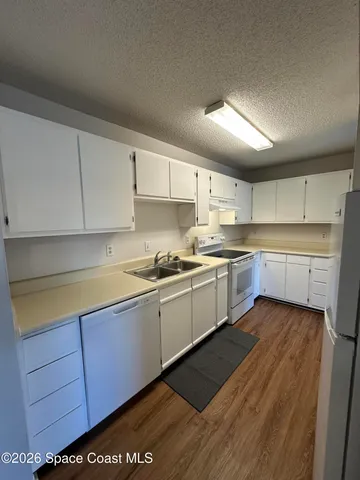 a kitchen with a sink window and cabinets