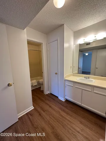 a spacious bathroom with a granite countertop sink and a mirror