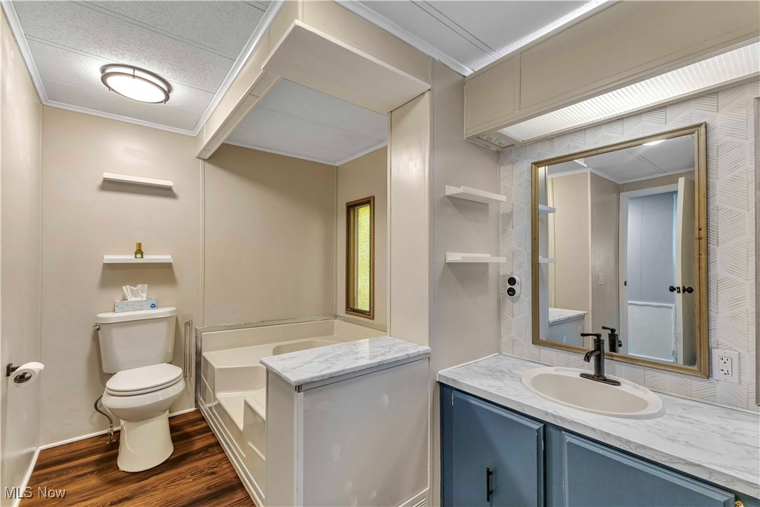 35157 Center Ridge Road, Unit 120 North Ridgeville, OH 44039 - Photo 19 of 25 Full bathroom with dark wood finished floors, vanity, crown molding, and a bath