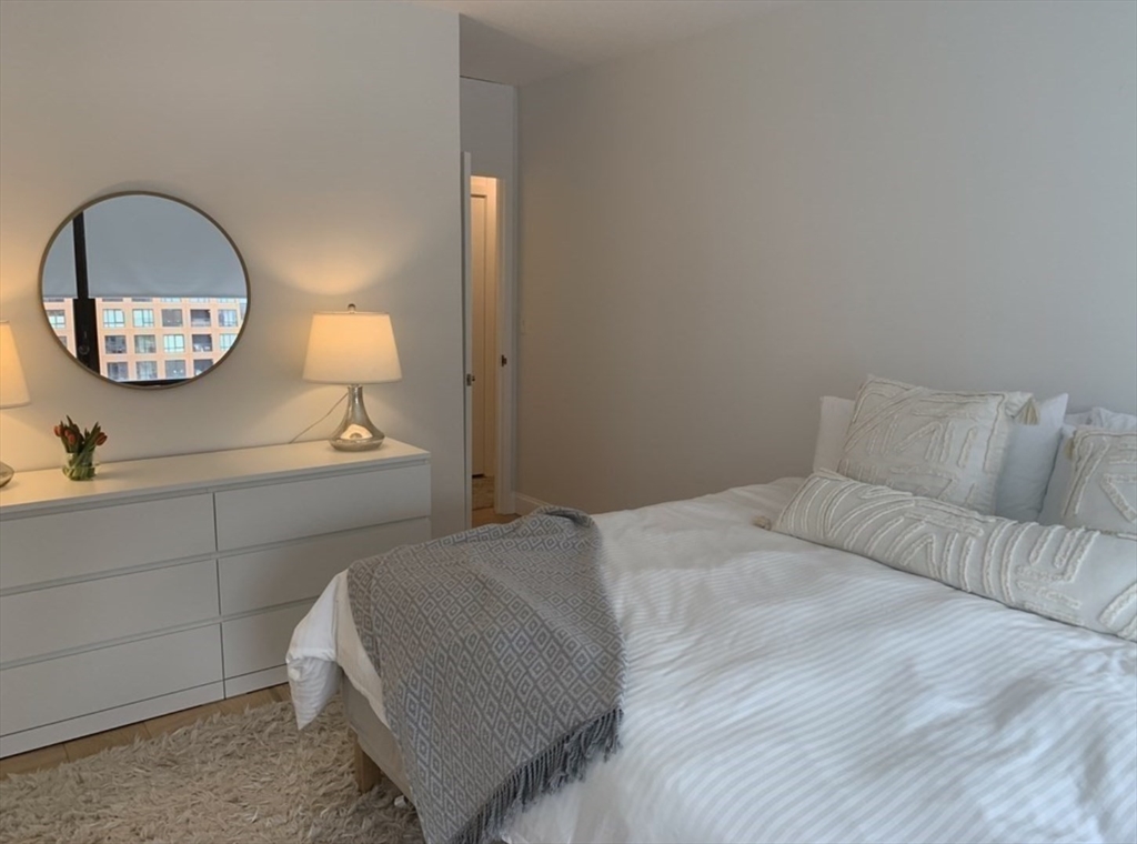 65 East India Row, Unit 10A Boston, MA 02110 - Photo 14 of 17 a bedroom with a bed and a mirror