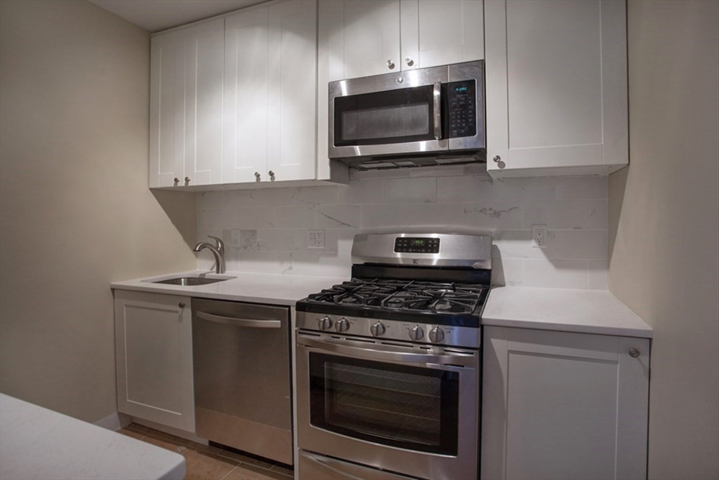 65 East India Row, Unit 10A Boston, MA 02110 - Photo 4 of 17 a kitchen with a stove and a microwave