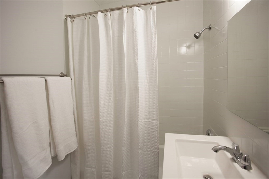 65 East India Row, Unit 10A Boston, MA 02110 - Photo 6 of 17 a bathroom with a sink and a mirror