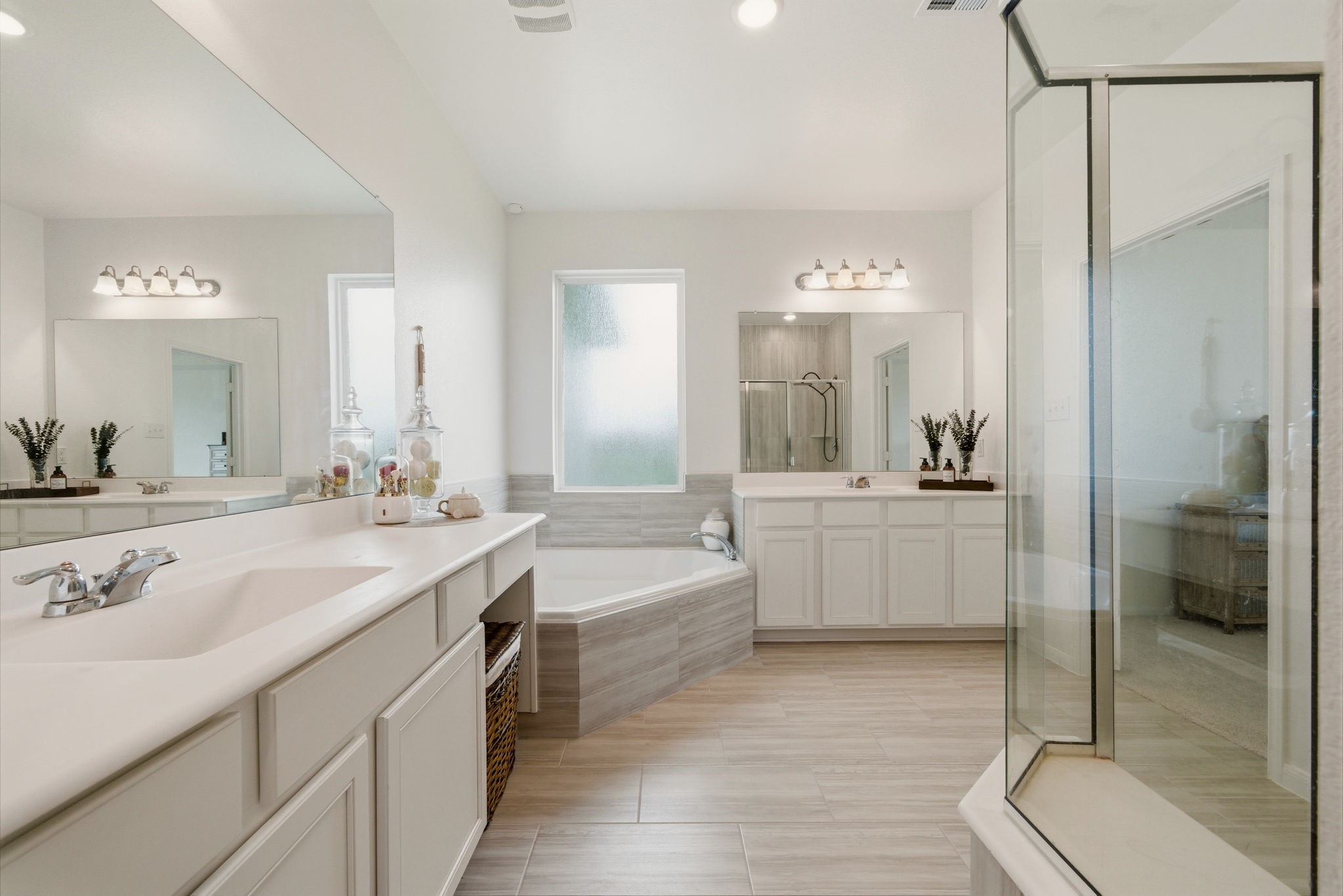 4012 Edgewater Ter Lane Waller, TX 77484 - Photo 32 of 42 a spacious bathroom with a double vanity sink a mirror and a bathtub