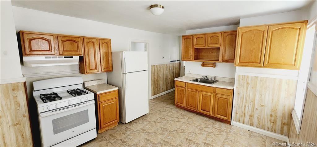 a kitchen with stainless steel appliances granite countertop a refrigerator and a stove top oven