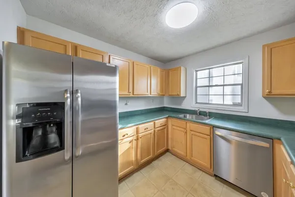 a kitchen with a refrigerator sink and cabinets