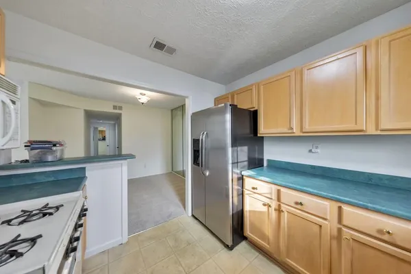 a kitchen with stainless steel appliances granite countertop a refrigerator and a stove
