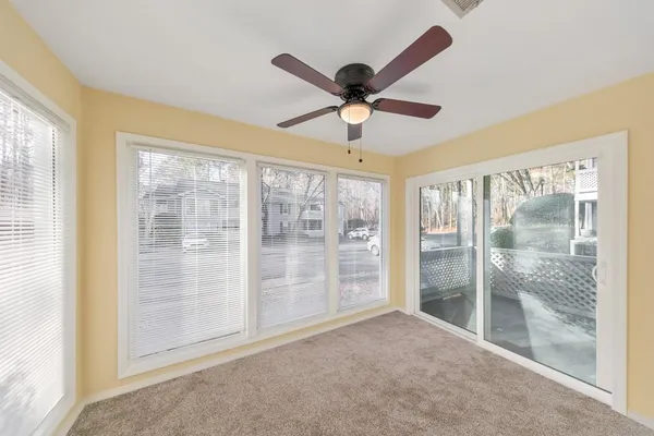 a view of empty room with wooden floor and fan