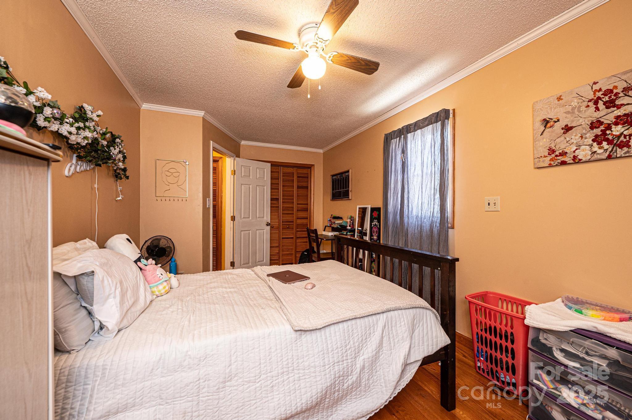 129 38th Street Northwest Hickory, NC 28601 - Photo 15 of 30 a bedroom with a bed dresser and a chandelier