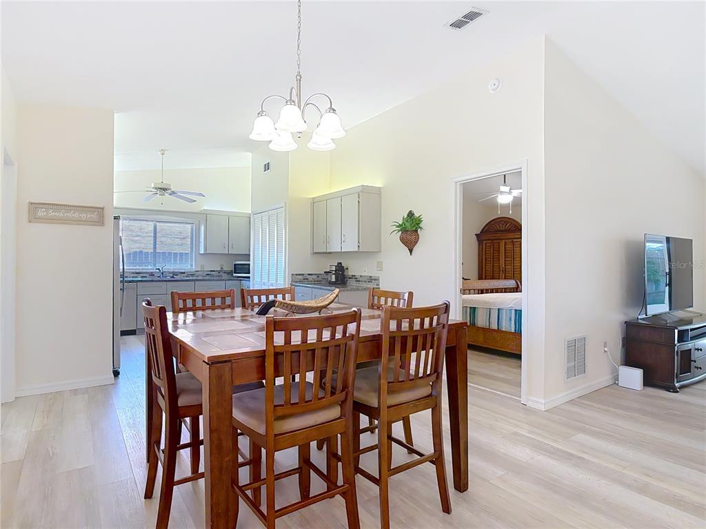 4761 Riverglen Boulevard Ponce Inlet, FL 32127 - Photo 11 of 50 a dining room with furniture a chandelier and wooden floor