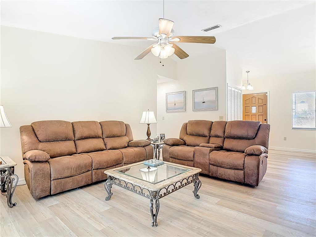 4761 Riverglen Boulevard Ponce Inlet, FL 32127 - Photo 15 of 50 a living room with furniture a large window and a chandelier