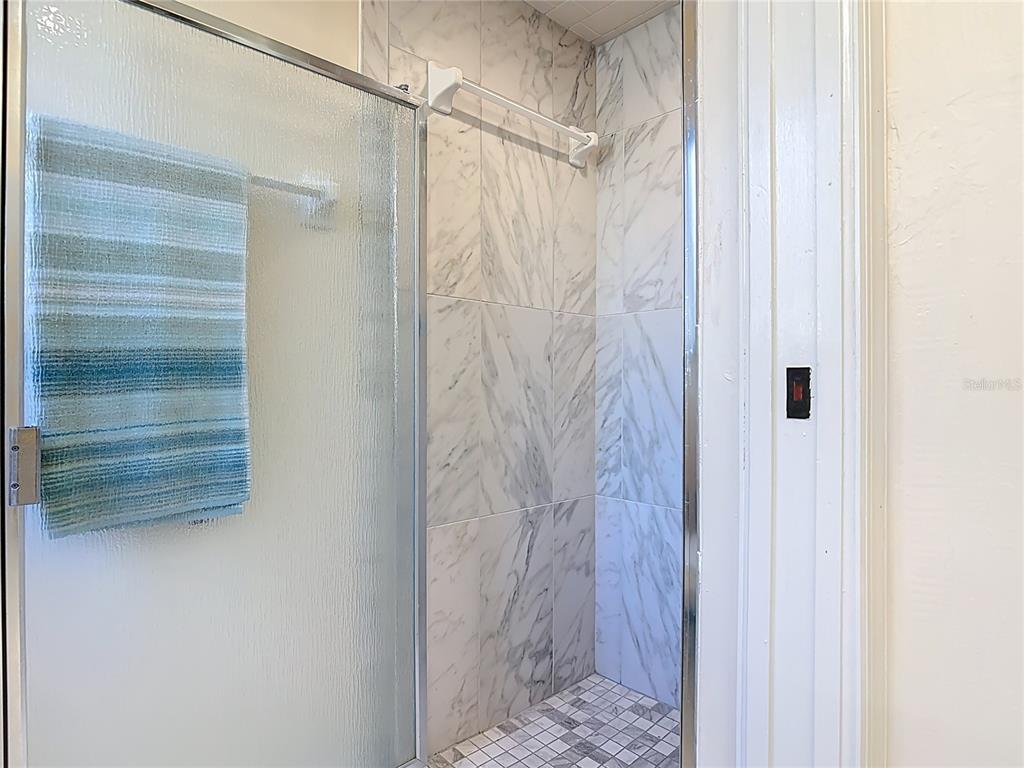 4761 Riverglen Boulevard Ponce Inlet, FL 32127 - Photo 19 of 50 a bathroom with a glass shower door