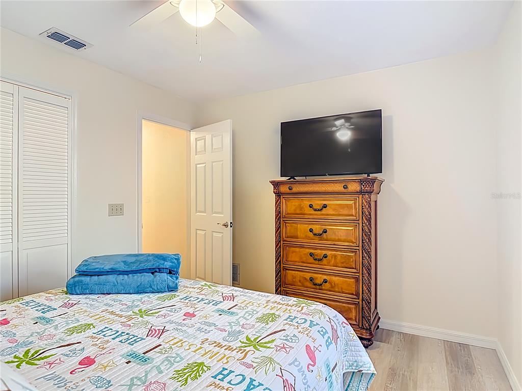 4761 Riverglen Boulevard Ponce Inlet, FL 32127 - Photo 21 of 50 a bedroom with a bed and a flat screen tv