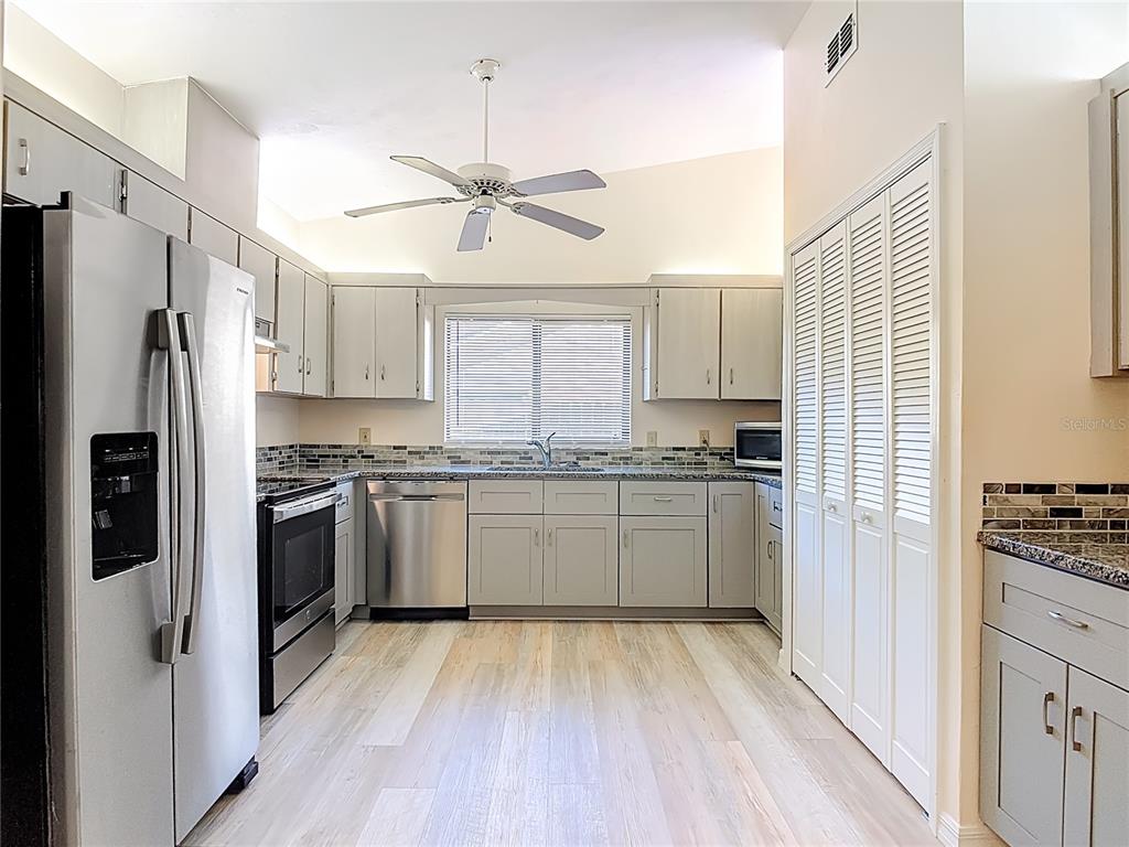 4761 Riverglen Boulevard Ponce Inlet, FL 32127 - Photo 7 of 50 a kitchen with a refrigerator stove and white cabinets