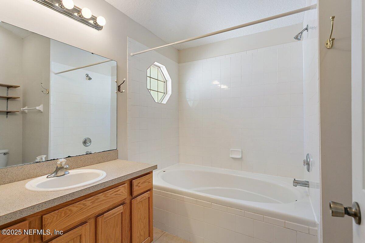 452 Dutton Island Road West Atlantic Beach, FL 32233 - Photo 11 of 28 a bathroom with a bathtub shower sink vanity and a mirror