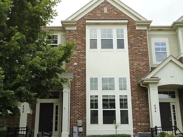 front view of a brick house with a yard