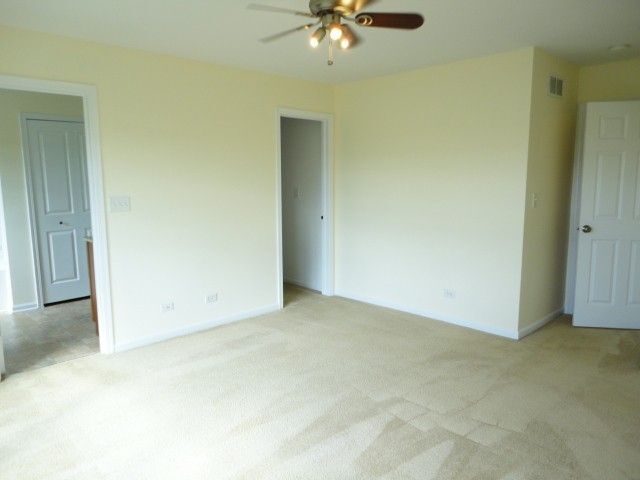 490 Grosvenor Lane Aurora, IL 60504 - Photo 13 of 16 an empty room with a ceiling fan and carpet