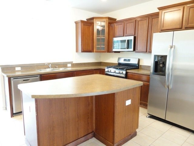 490 Grosvenor Lane Aurora, IL 60504 - Photo 2 of 16 a kitchen with stainless steel appliances granite countertop a refrigerator and a stove