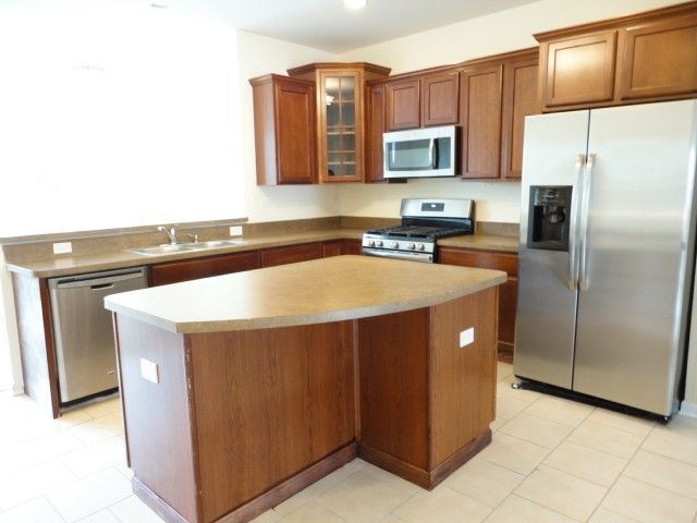 490 Grosvenor Lane Aurora, IL 60504 - Photo 3 of 16 a kitchen with stainless steel appliances granite countertop a refrigerator a stove a sink and a microwave