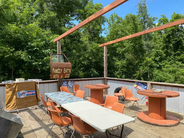 a view of outdoor space with seating area and trees in the background