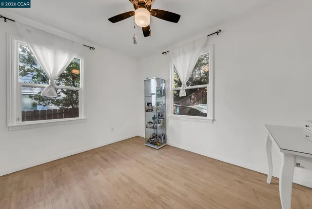 a view of empty room with wooden floor and window