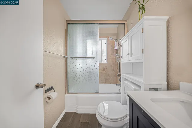 a bathroom with a granite countertop sink toilet a shower and a mirror