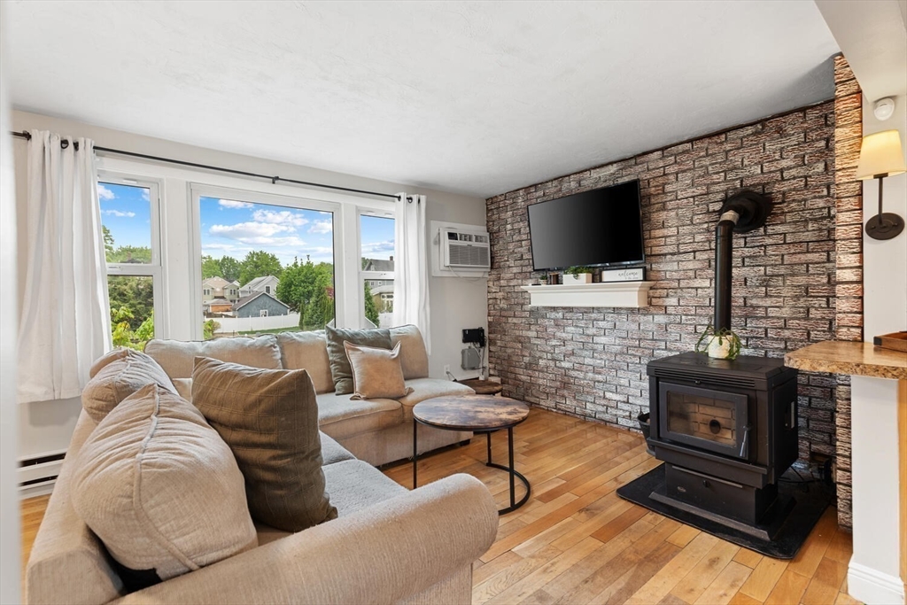 12 Wright Street, Unit 2 Stoneham, MA 02180 - Photo 12 of 35 a living room with furniture a flat screen tv and a fireplace