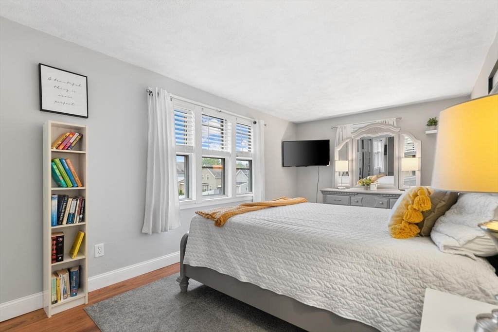 12 Wright Street, Unit 2 Stoneham, MA 02180 - Photo 25 of 35 a bedroom with a bed large window and book shelf