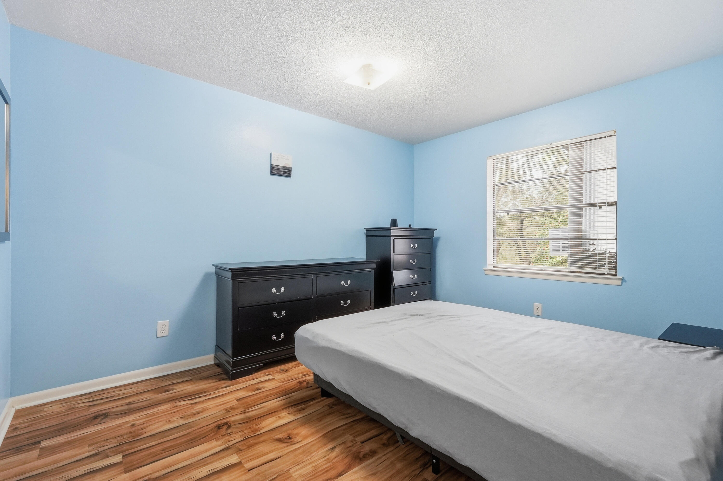 41 12th Street, Unit 68 Shalimar, FL 32579 - Photo 17 of 32 a bedroom with a bed and wooden floor