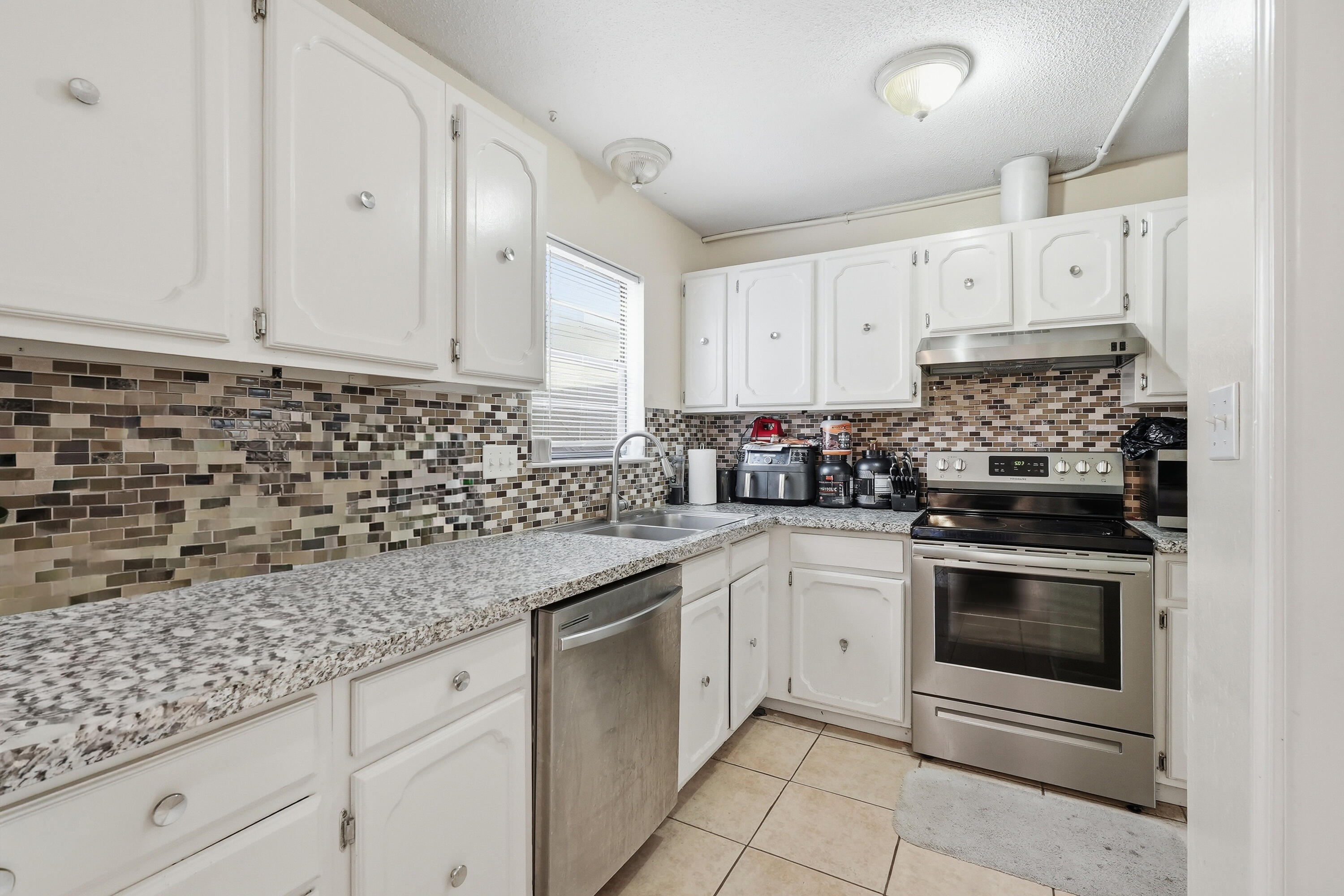 41 12th Street, Unit 68 Shalimar, FL 32579 - Photo 5 of 32 a kitchen with granite countertop white cabinets and white stainless steel appliances