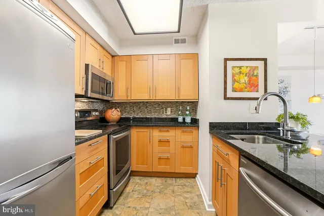 a kitchen with stainless steel appliances granite countertop a sink and a stove