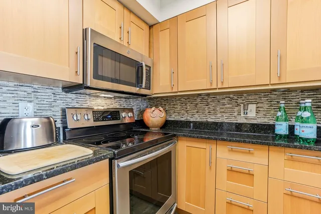 a kitchen with granite countertop a stove sink and cabinets