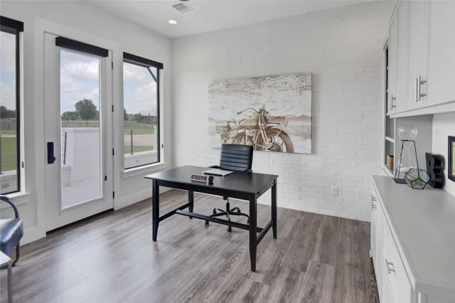 a view of a workspace with furniture and a window