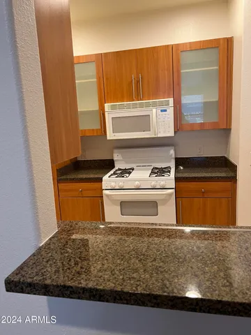 a kitchen with a stove window and cabinets