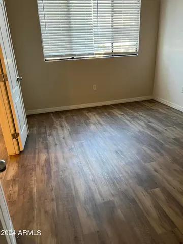 a view of a room that has wooden floor and a window