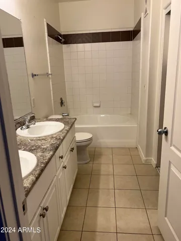 a bathroom with a granite countertop sink a toilet and shower