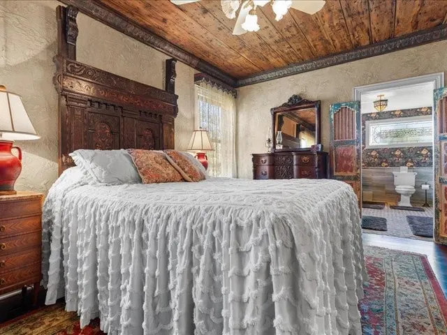 a bed sitting in a bedroom next to a window