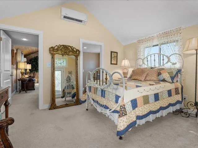 a white bed sitting in a room next to a lamp