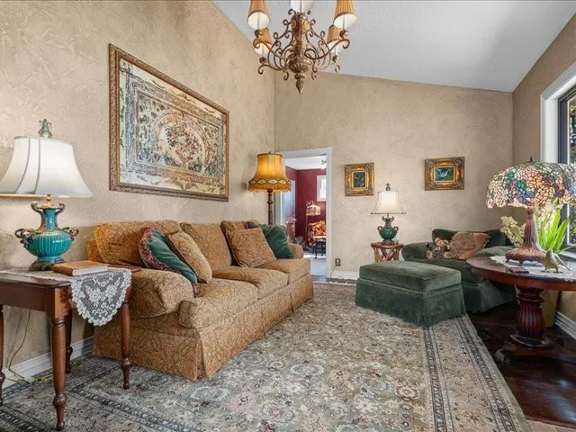 a living room with furniture a chandelier and a window