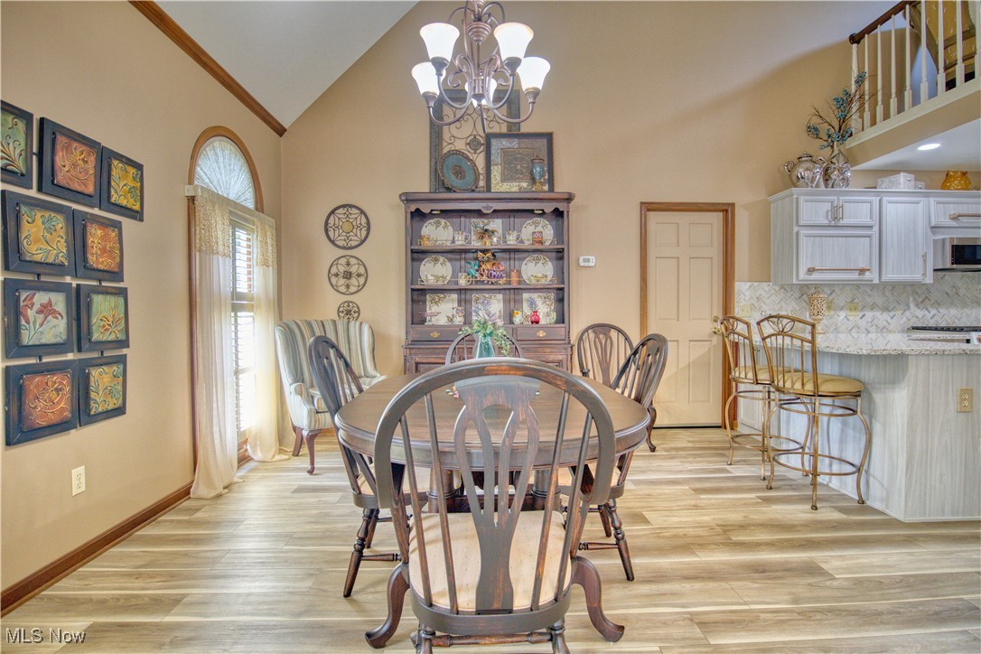 7017 Kirk Road Canfield, OH 44406 - Photo 10 of 35 Dining room with a chandelier, light wood finished floors, and high vaulted ceiling