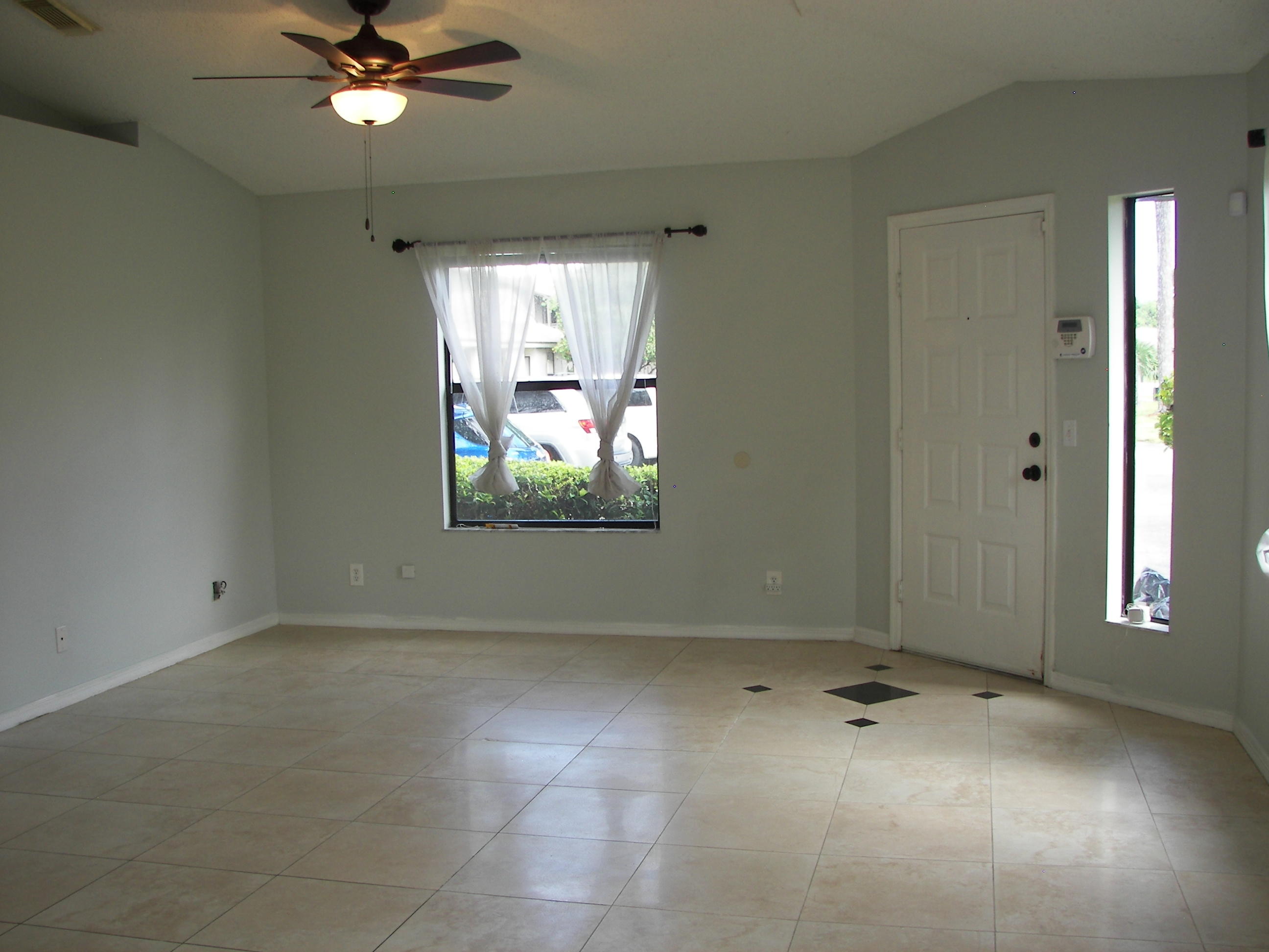 2827 Stoneway Lane, Unit D Fort Pierce, FL 34982 - Photo 2 of 25 an empty room with windows and fan