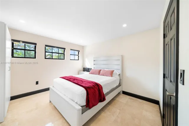 a bedroom with a large bed and a large window