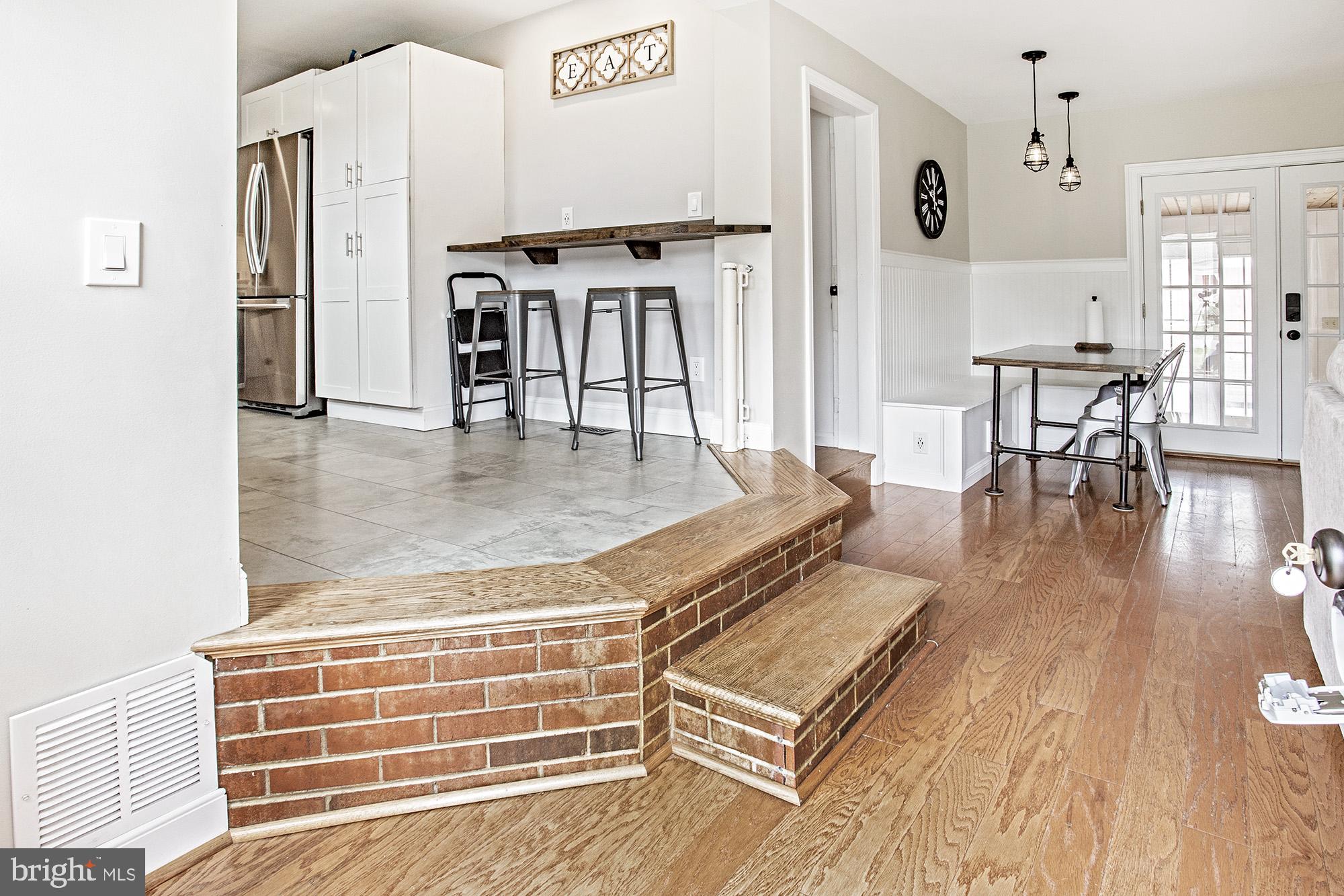 5000 Ogletown Stanton Road Newark, DE 19713 - Photo 3 of 39 a living room with furniture a table and kitchen view with wooden floor
