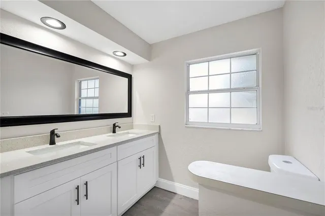 a view of an empty room with wooden floor and windows