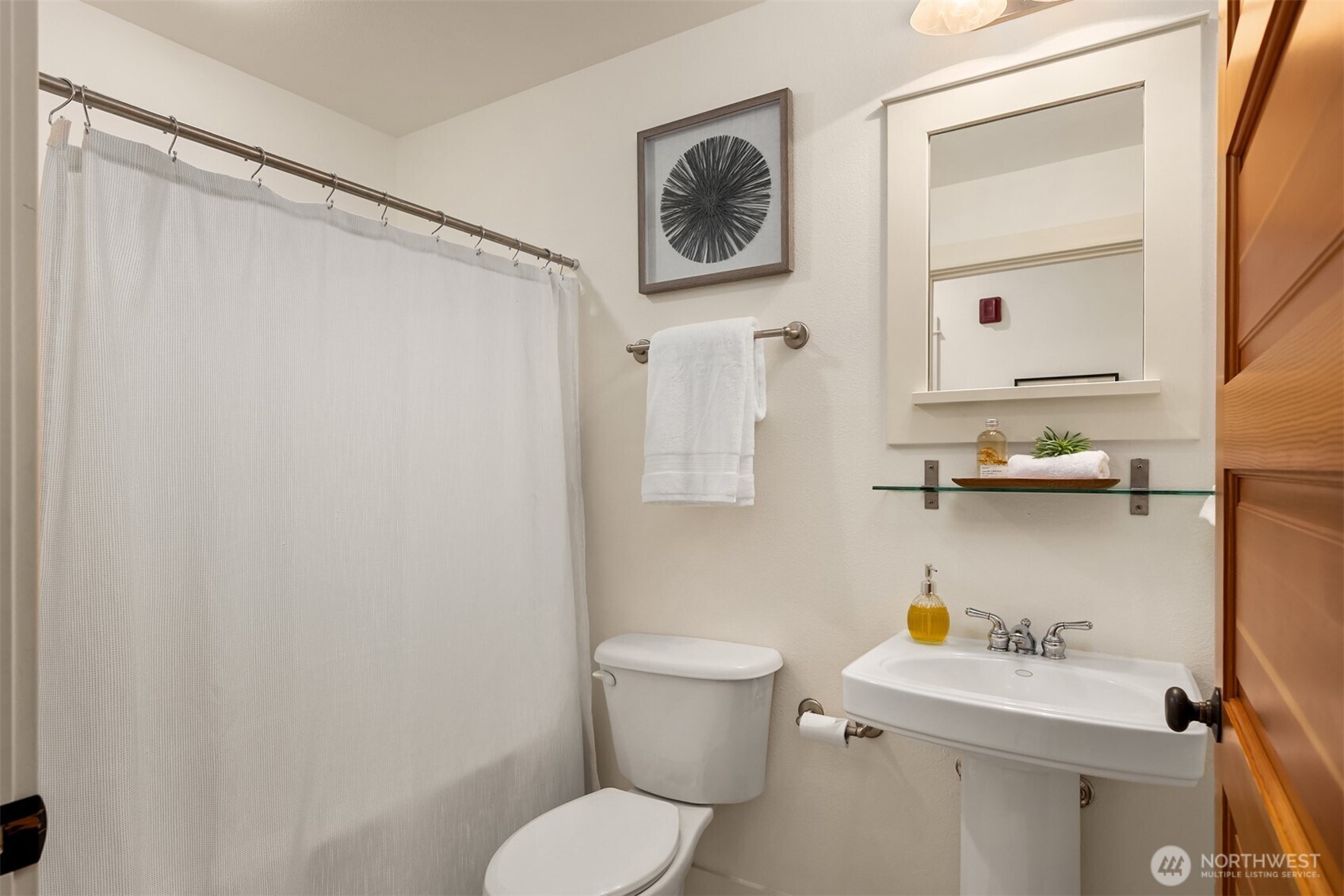 144 Hall Brothers Loop Northwest, Unit 101 Bainbridge Island, WA 98110 - Photo 22 of 30 a bathroom with a sink a toilet and a mirror