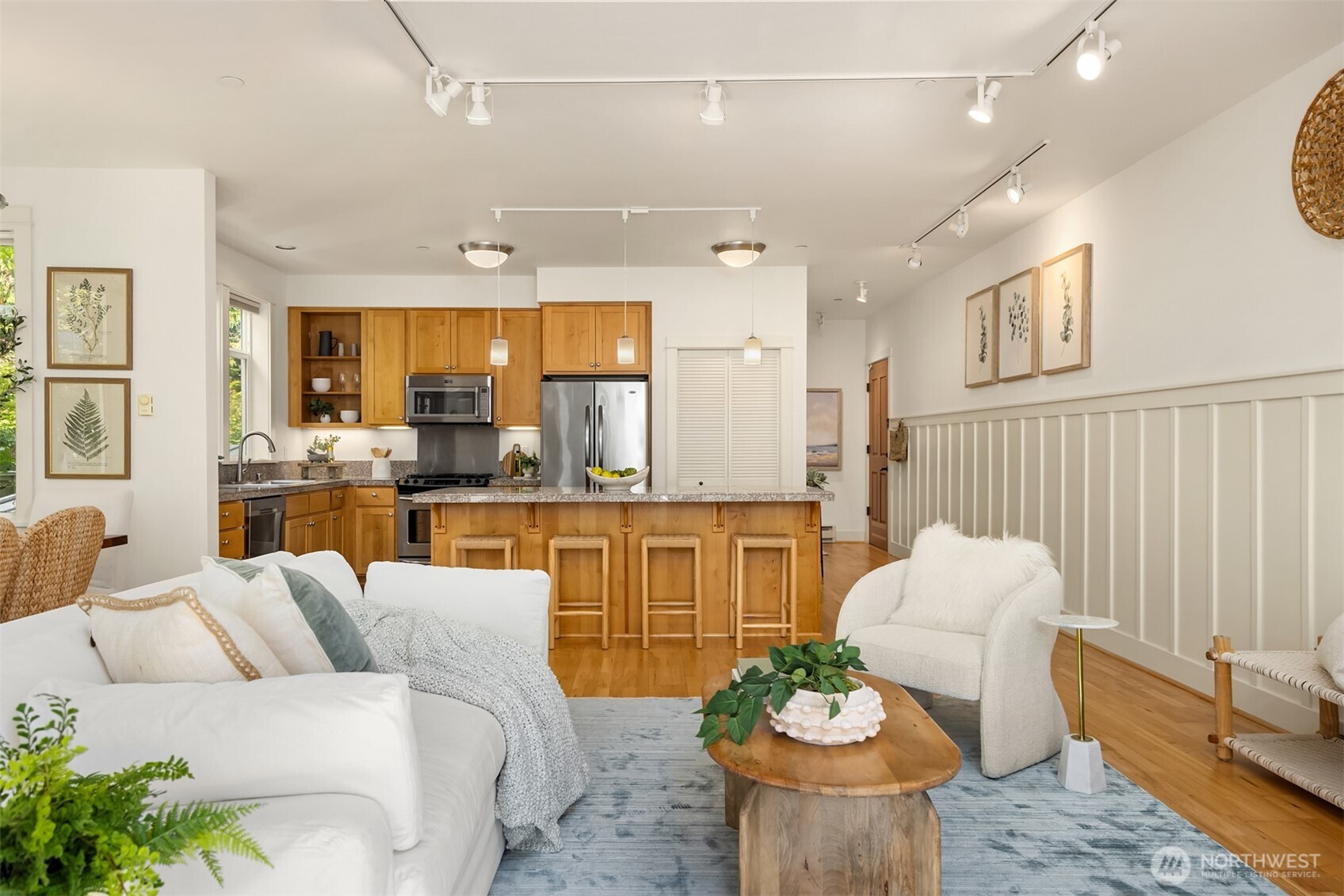 144 Hall Brothers Loop Northwest, Unit 101 Bainbridge Island, WA 98110 - Photo 9 of 28 a living room with furniture and a dining table with kitchen view