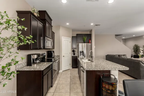 a kitchen with granite countertop kitchen island stainless steel appliances a sink stove and refrigerator