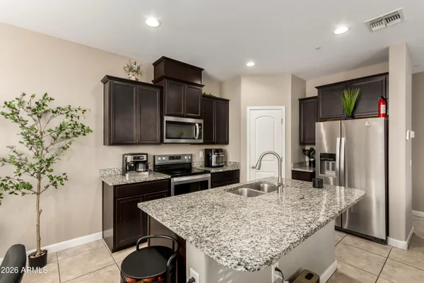 a kitchen with granite countertop a sink and stainless steel appliances