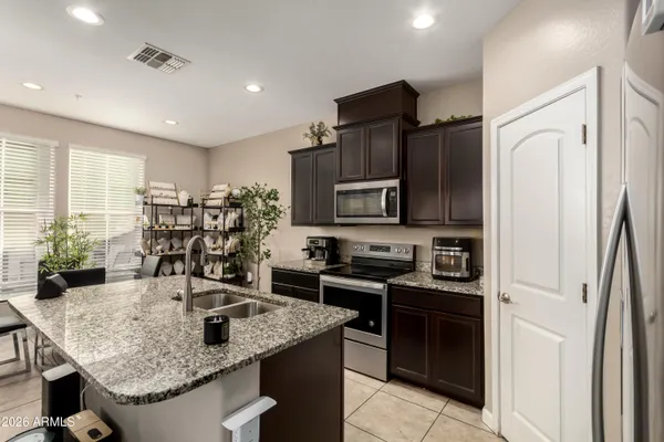 a kitchen with stainless steel appliances granite countertop a sink stove and refrigerator